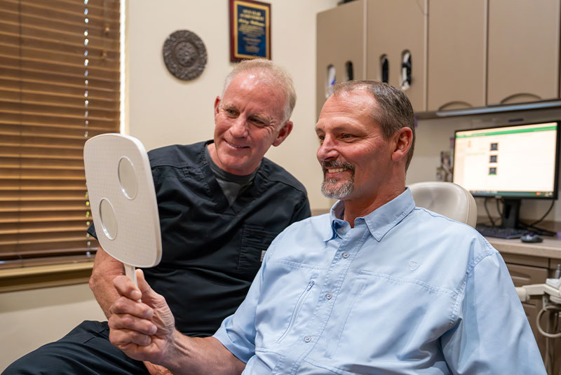 Patient and doctor looking into mirror together