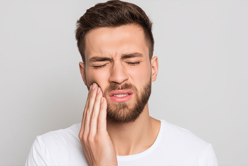 Man holding mouth in pain
