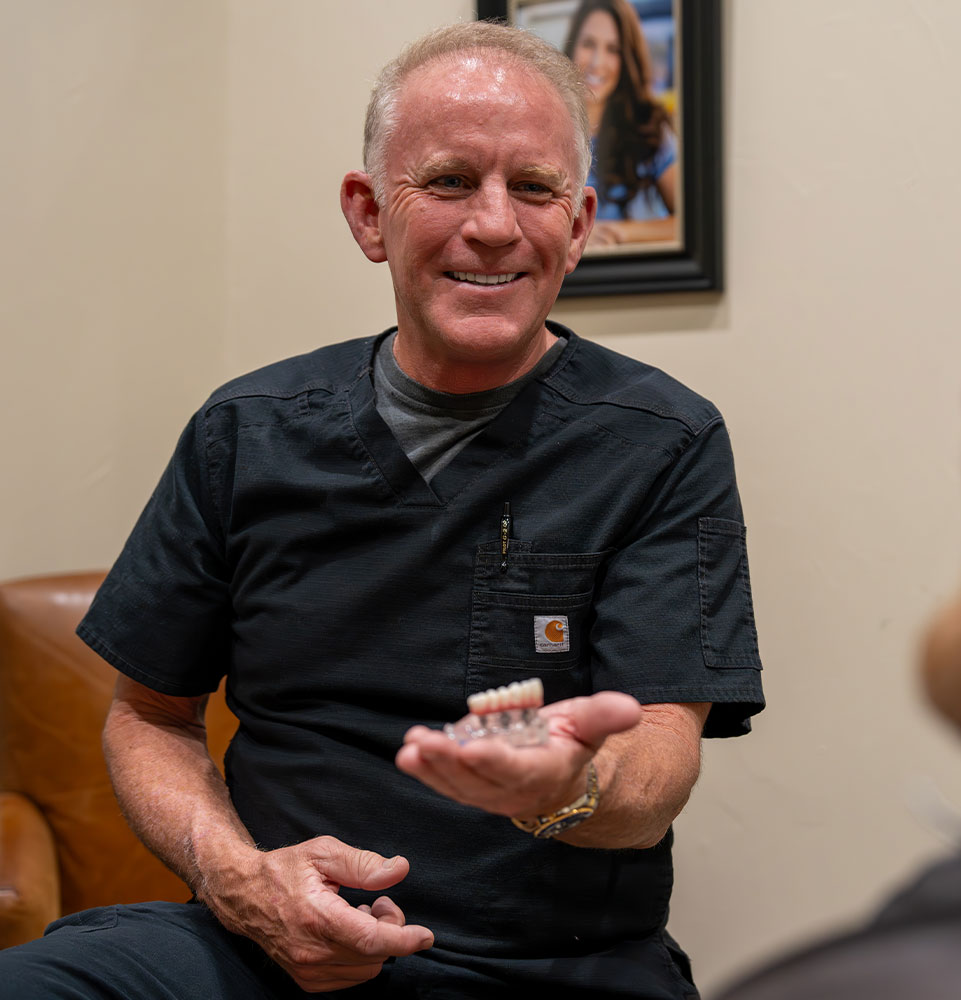 Doctor Holding a model of dental implants