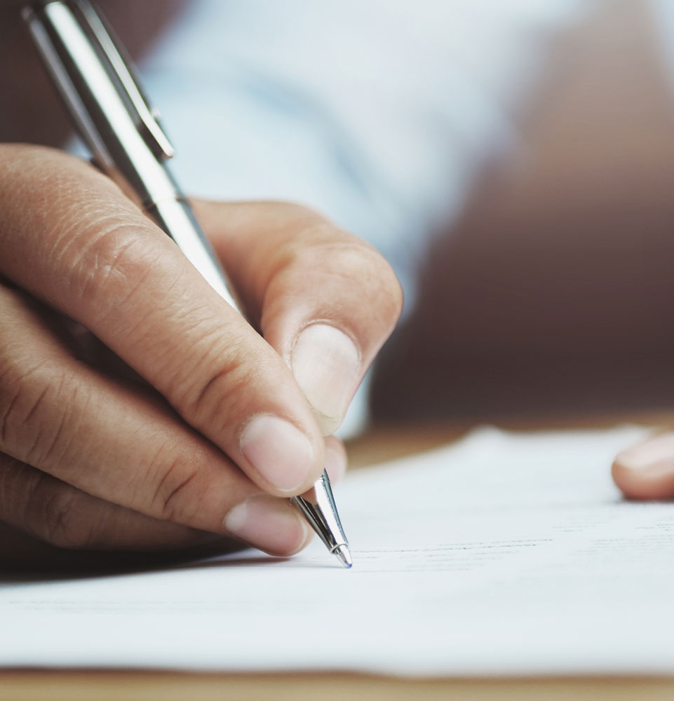 man writing on paper