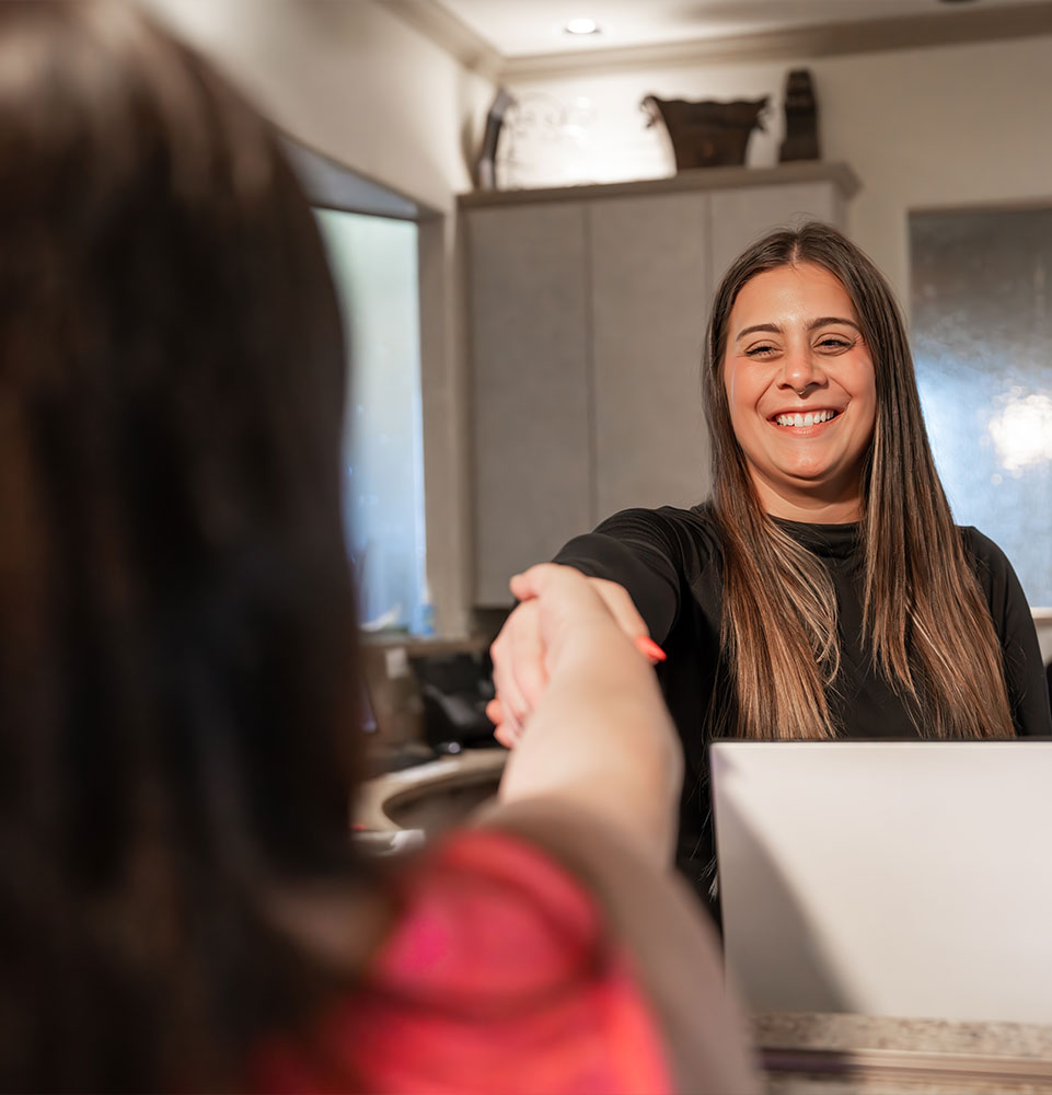 Patient greeting team member into dental office